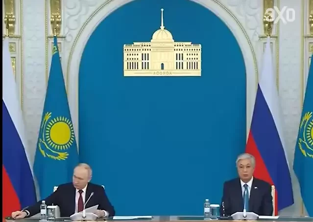 Путин тянется к наушнику, чтобы послушать Токаева. Фото: Скрин видео echofm.online