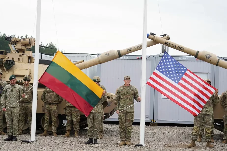 Салдаты трымаюць літоўскі і амерыканскі сцягі падчас цырымоніі адкрыцця лагера арміі ЗША Геркус у літоўскім Пабрадэ. 30 жніўня 2021 года. Фота: REUTERS / Яніс Лайзанс.