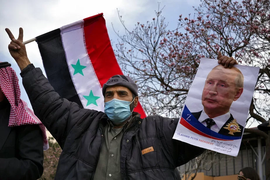 Сириец держит портрет президента России Владимира Путина и сирийский флаг во время демонстрации в поддержку вторжения России в Украину, 20 марта 2022 г. Фото: Bilal Hussein/ AP
